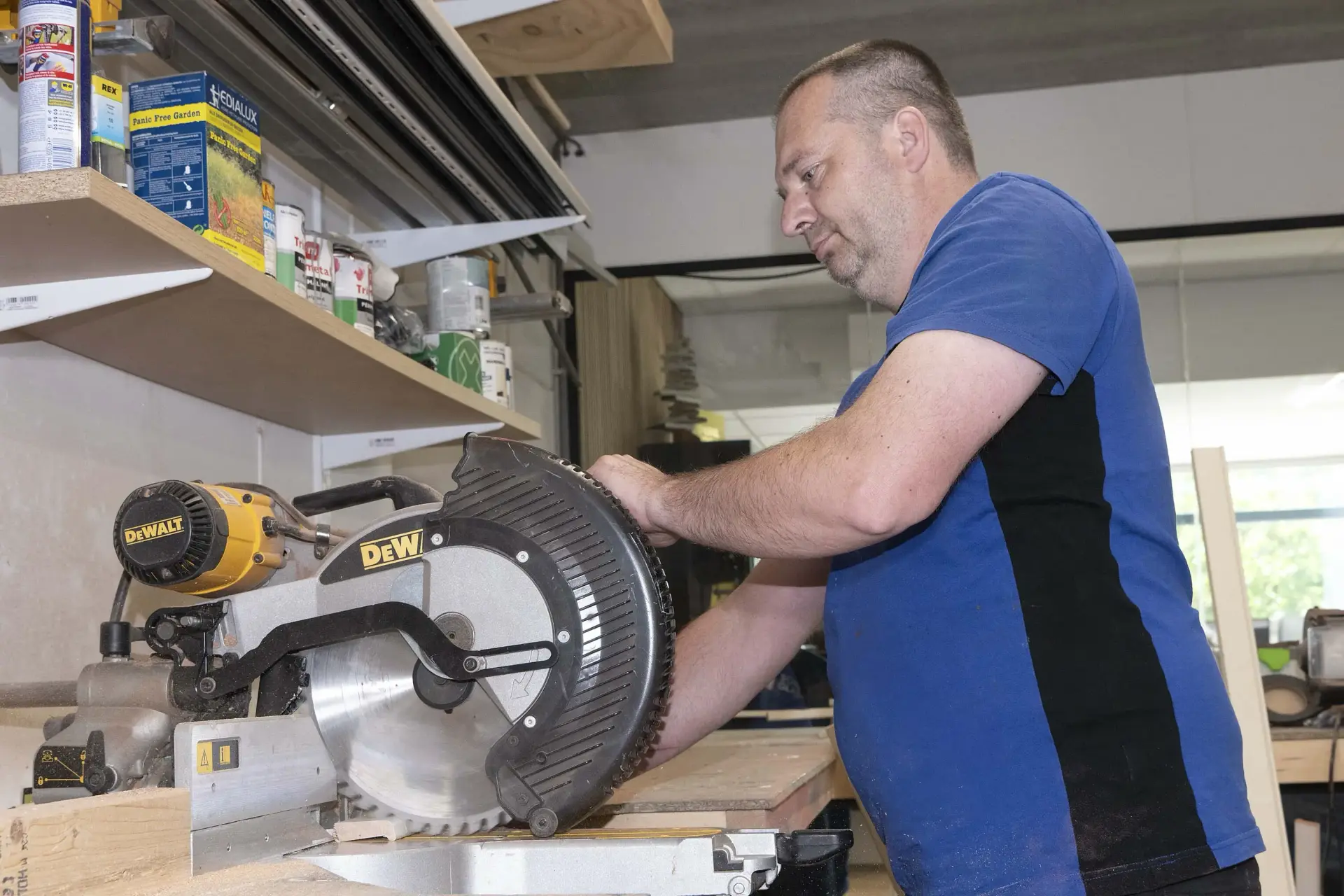 Sander zaagt glaslatten op maat in de werkplaats van Scheffer Glas.