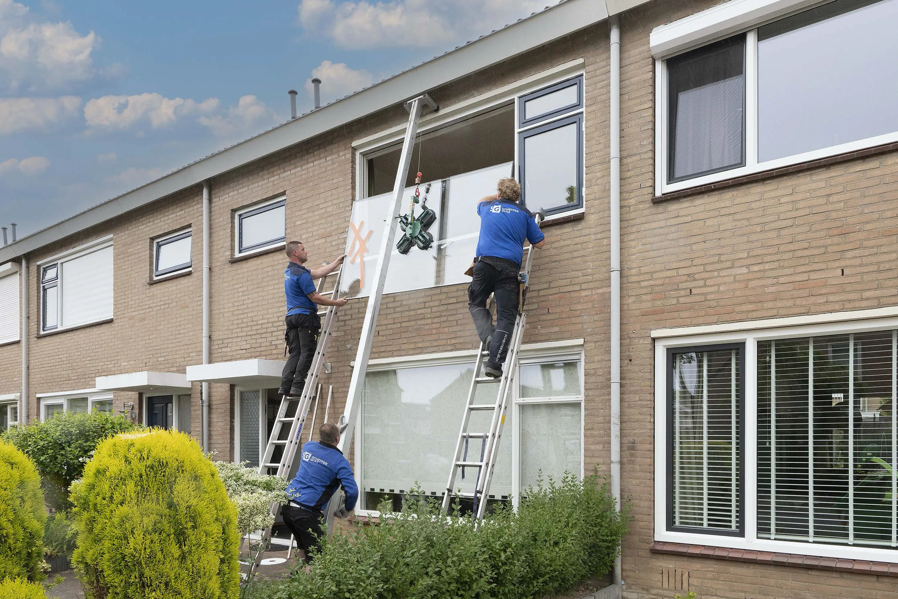 Sander, Bram en Edwin van Scheffer Glas plaatsen een nieuw raam in Zevenaar.
