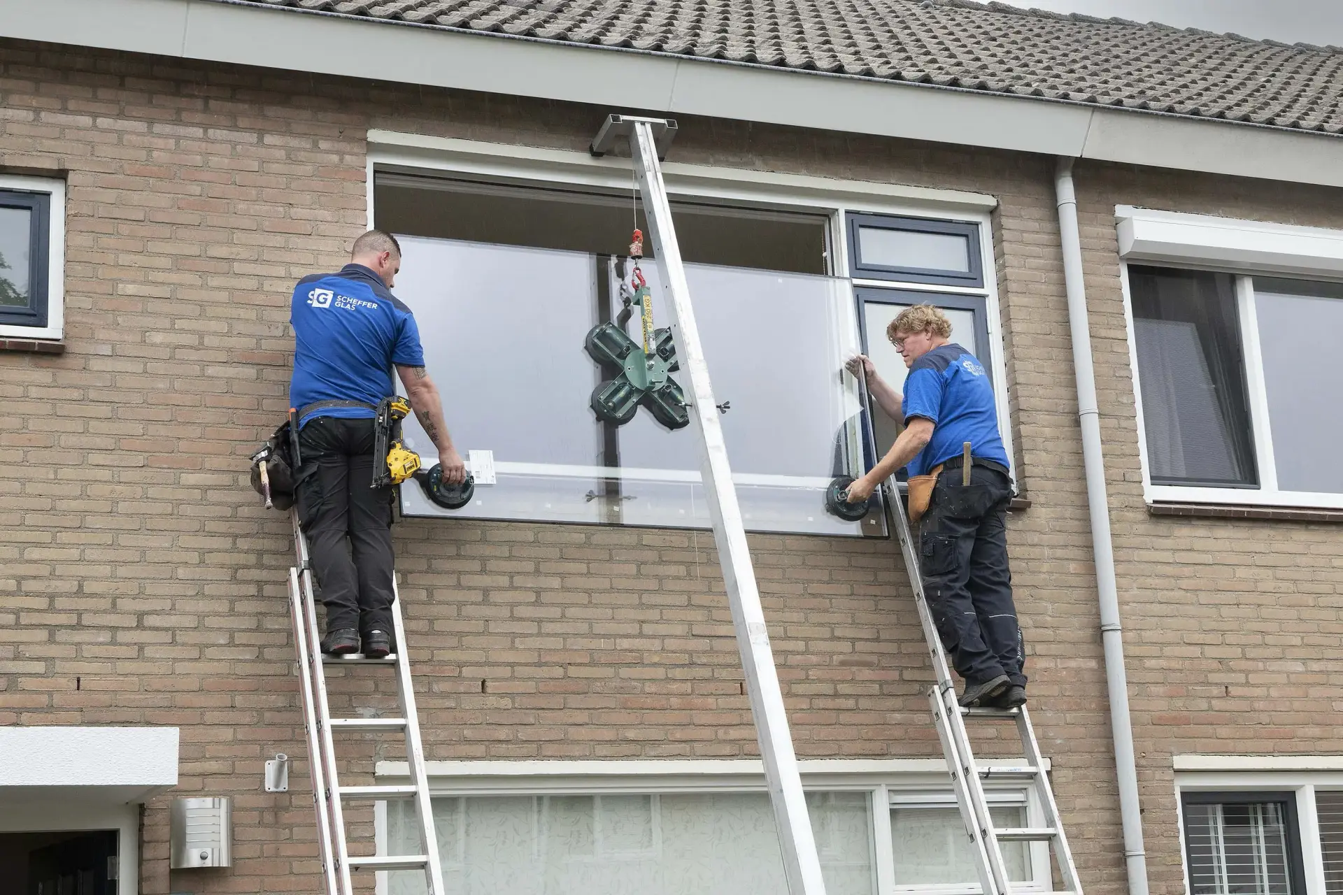 Edwin en Bram van Scheffer Glas plaatsen een nieuw raam op de eerste verdieping.